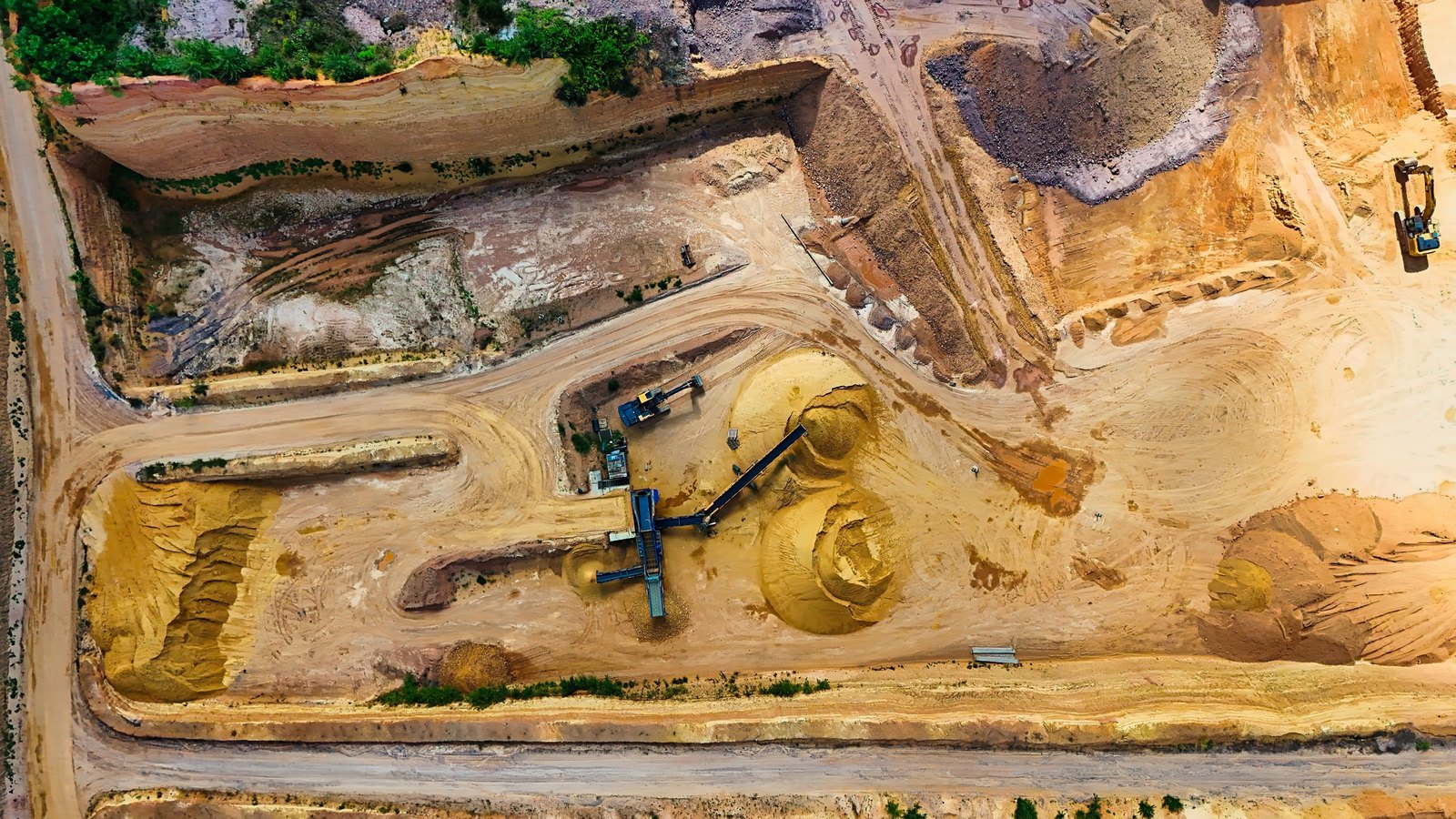An aerial view of sand excavation, conveyor equipment and unpaved haul roads, not a photograph of this event.