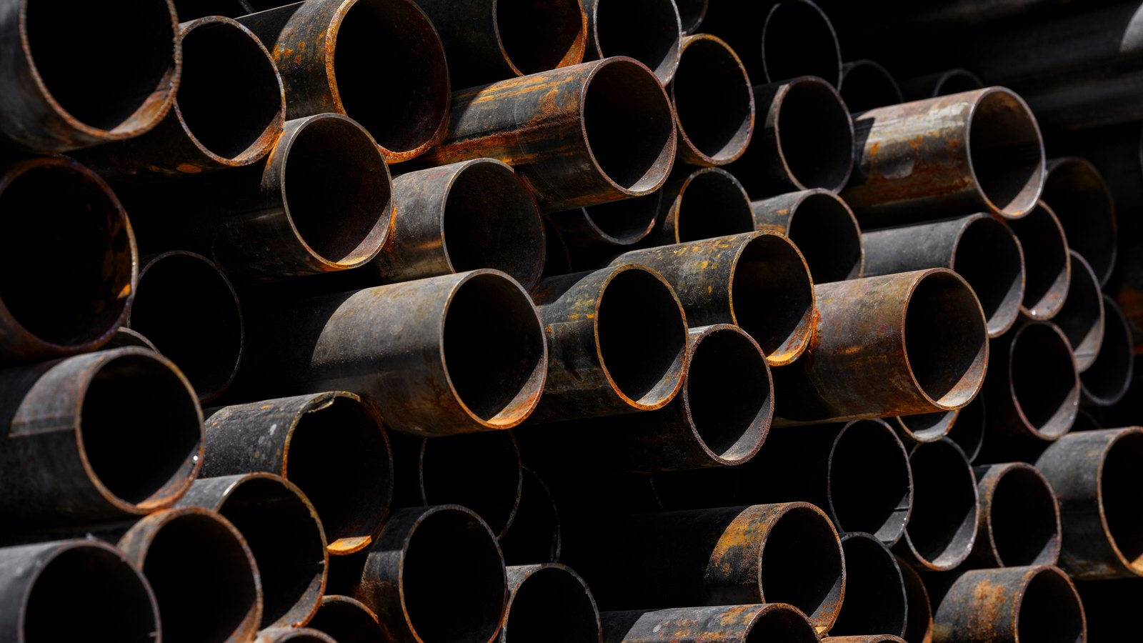A photograph illustrating stacked steel pipes.
