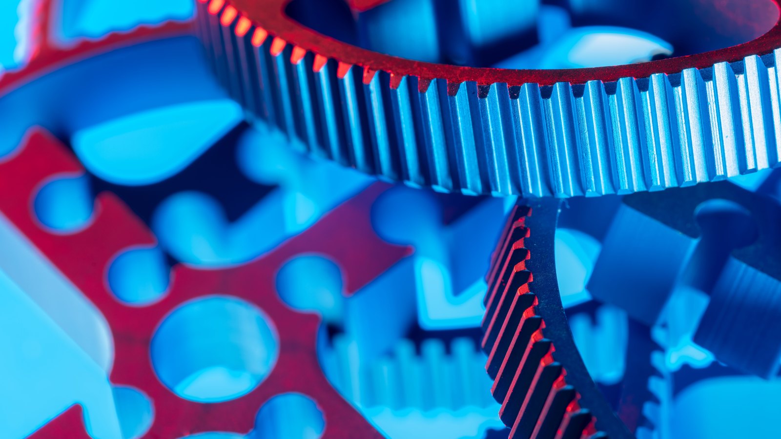 A photograph illustrating interlocking steel gear teeth inside industrial machinery close macro.