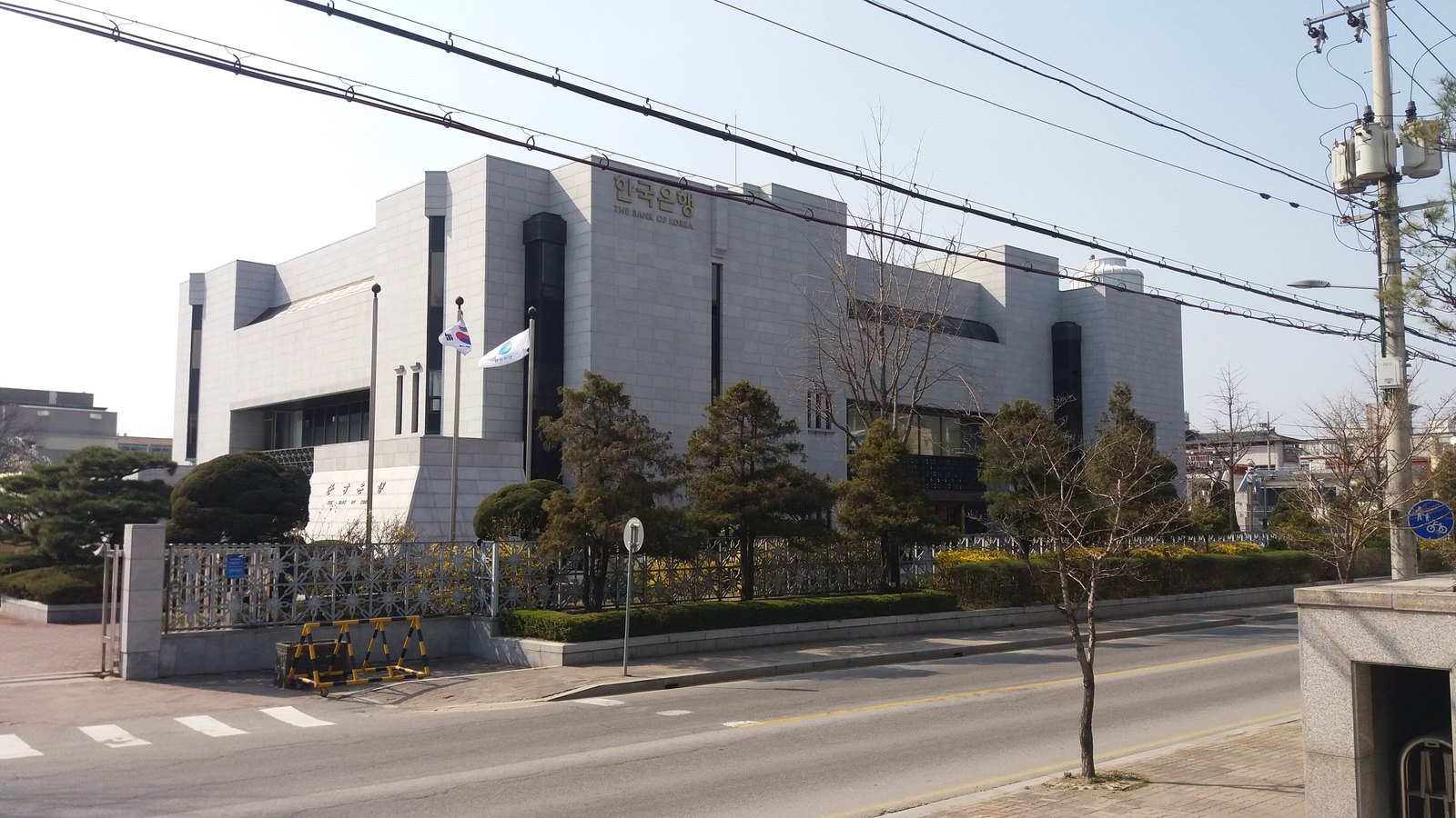 The Bank of Korea Chungbuk branch, a pale stone office building behind national and central-bank flags.