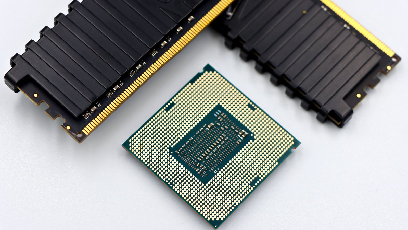 Two computer memory modules and a processor on a white background.