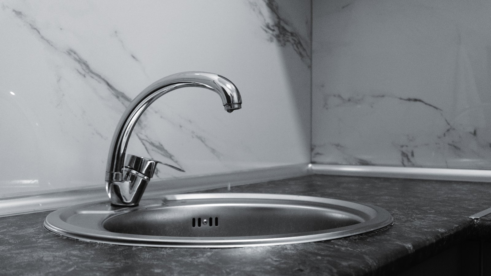 An unused chrome kitchen faucet above an empty sink, not a photograph of this advisory.