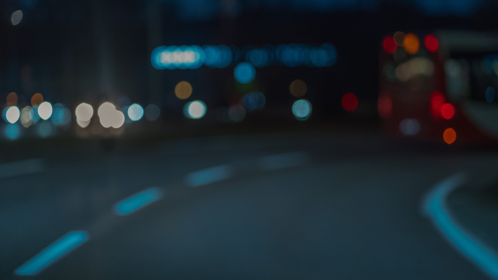 Defocused vehicle lights glow along a generic nighttime road, not a photograph of this crash.