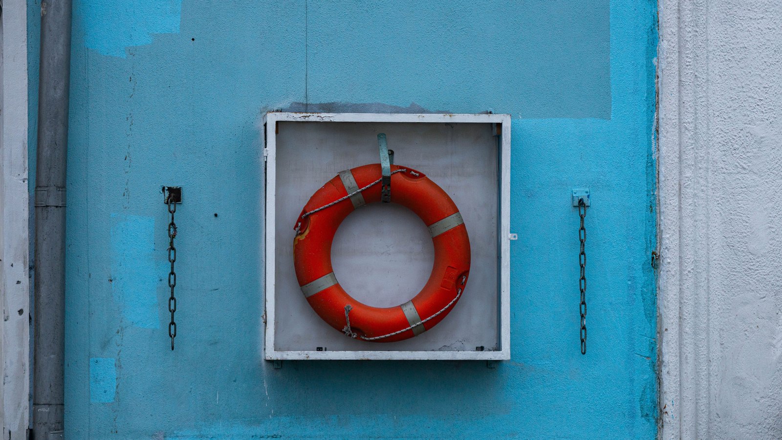 An orange life ring in a wall-mounted holder on a blue wall, not a photograph of this event.