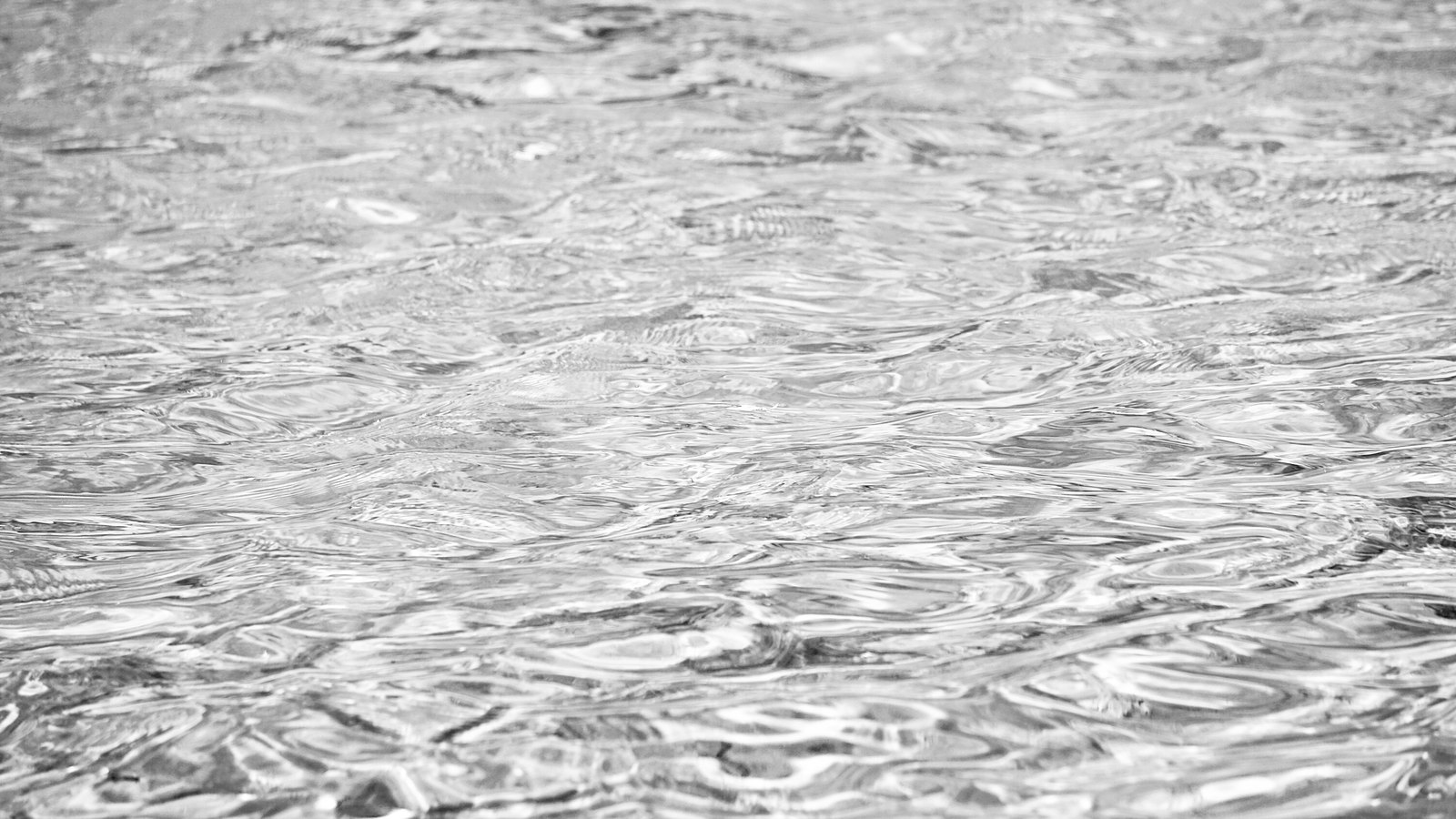 A close crop of rippled open water filling the frame in near monochrome, the surface broken into overlapping ridges of light and shadow. No shoreline, boat, structure, person or lettering is visible. It is used as an illustration and is not a photograph of the Orange River.