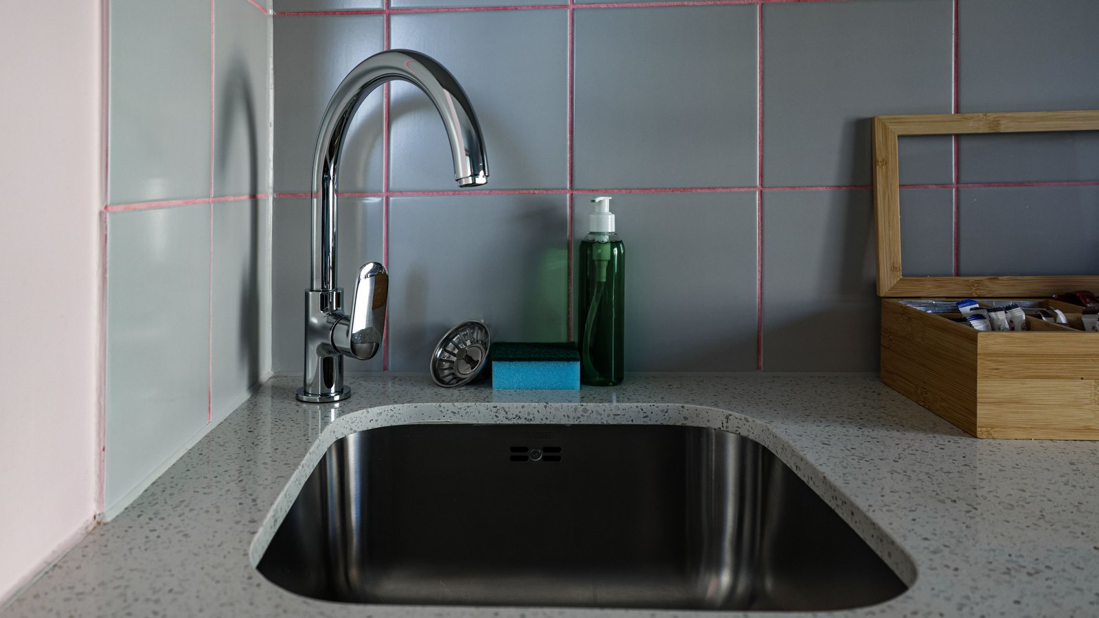 Chrome faucet above an empty stainless-steel kitchen sink, not a photograph of this event.