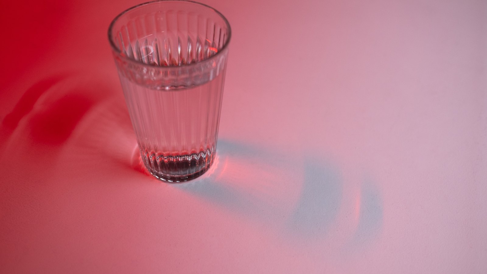 A clear glass of water under red light, not a photograph of this event.