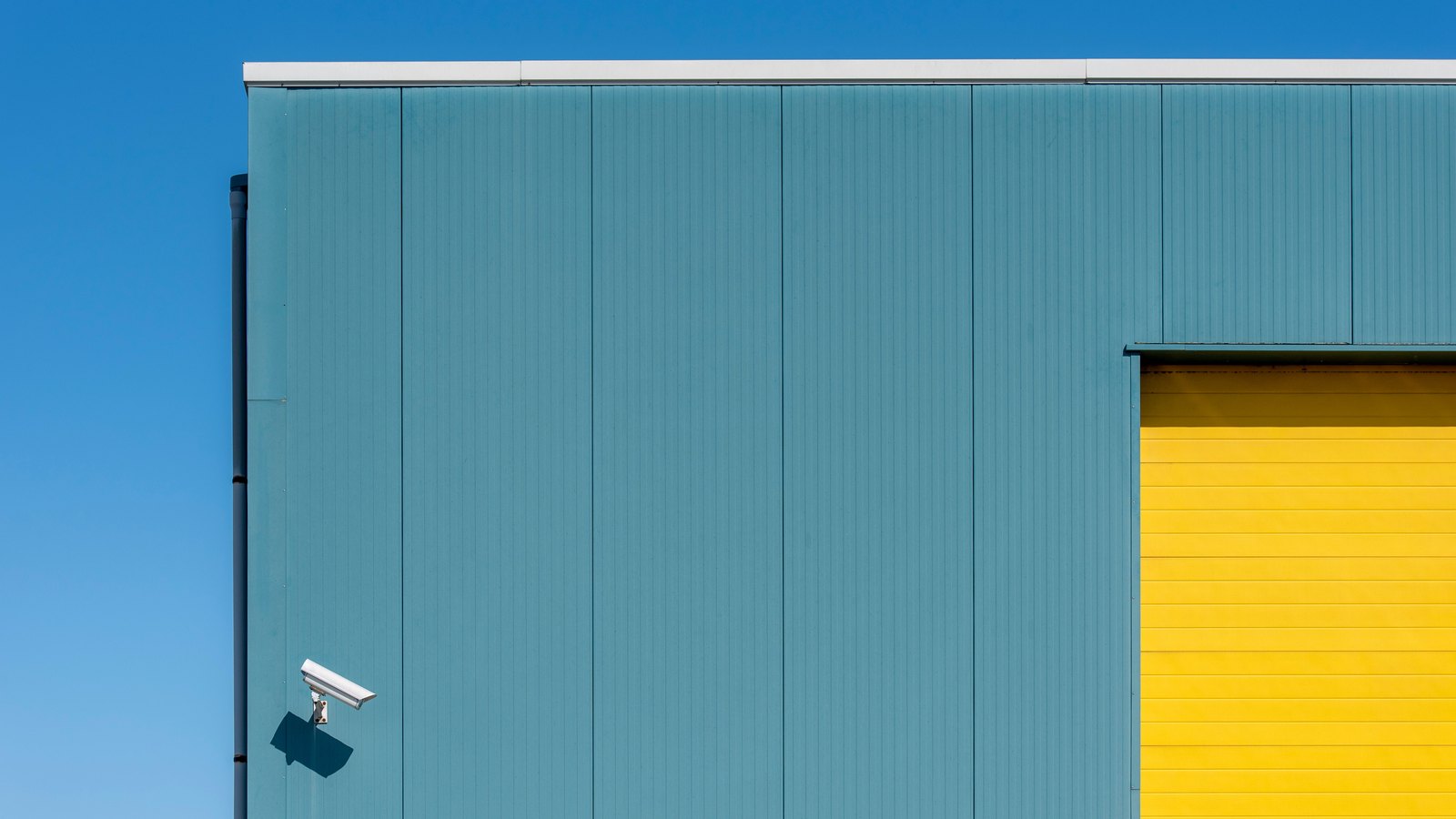 A security camera mounted on a blue exterior wall, not a photograph of this event.