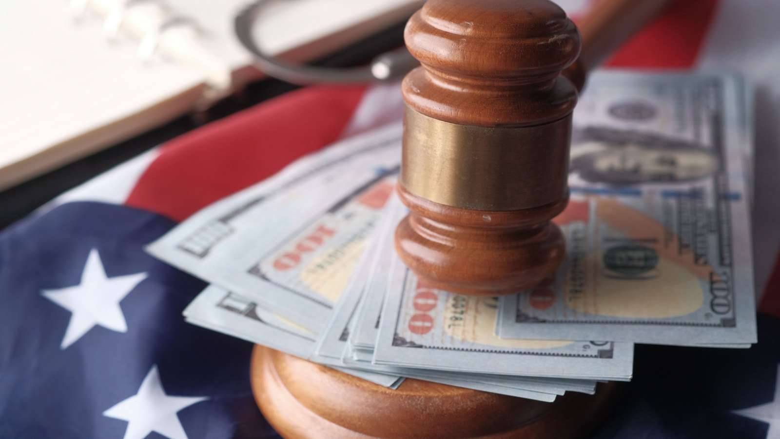 Wooden gavel resting on U.S. currency, not a photograph of this event.