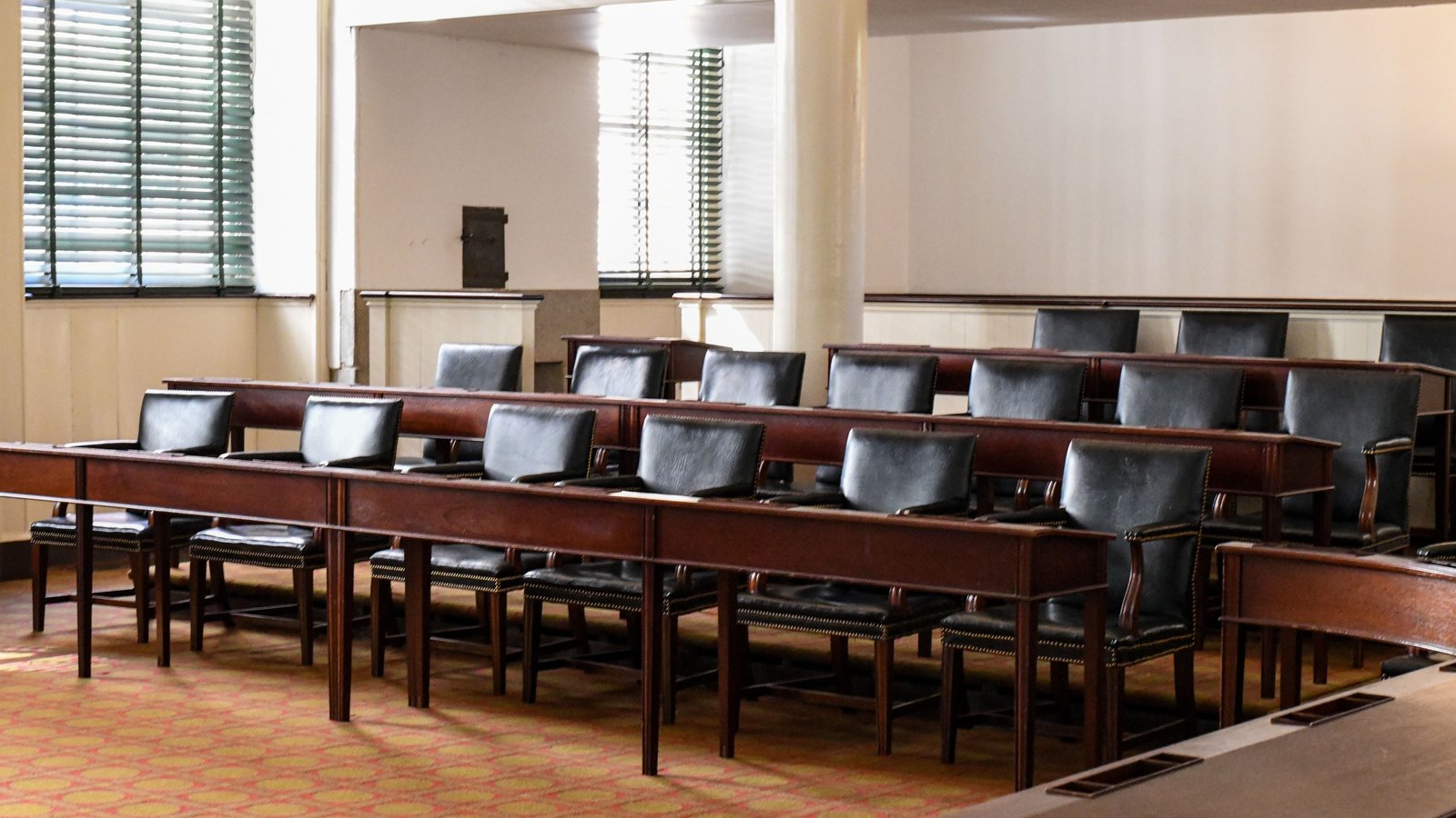 An empty modern conference room with a long table and black chairs, not a photograph of a Marco Island budget meeting.