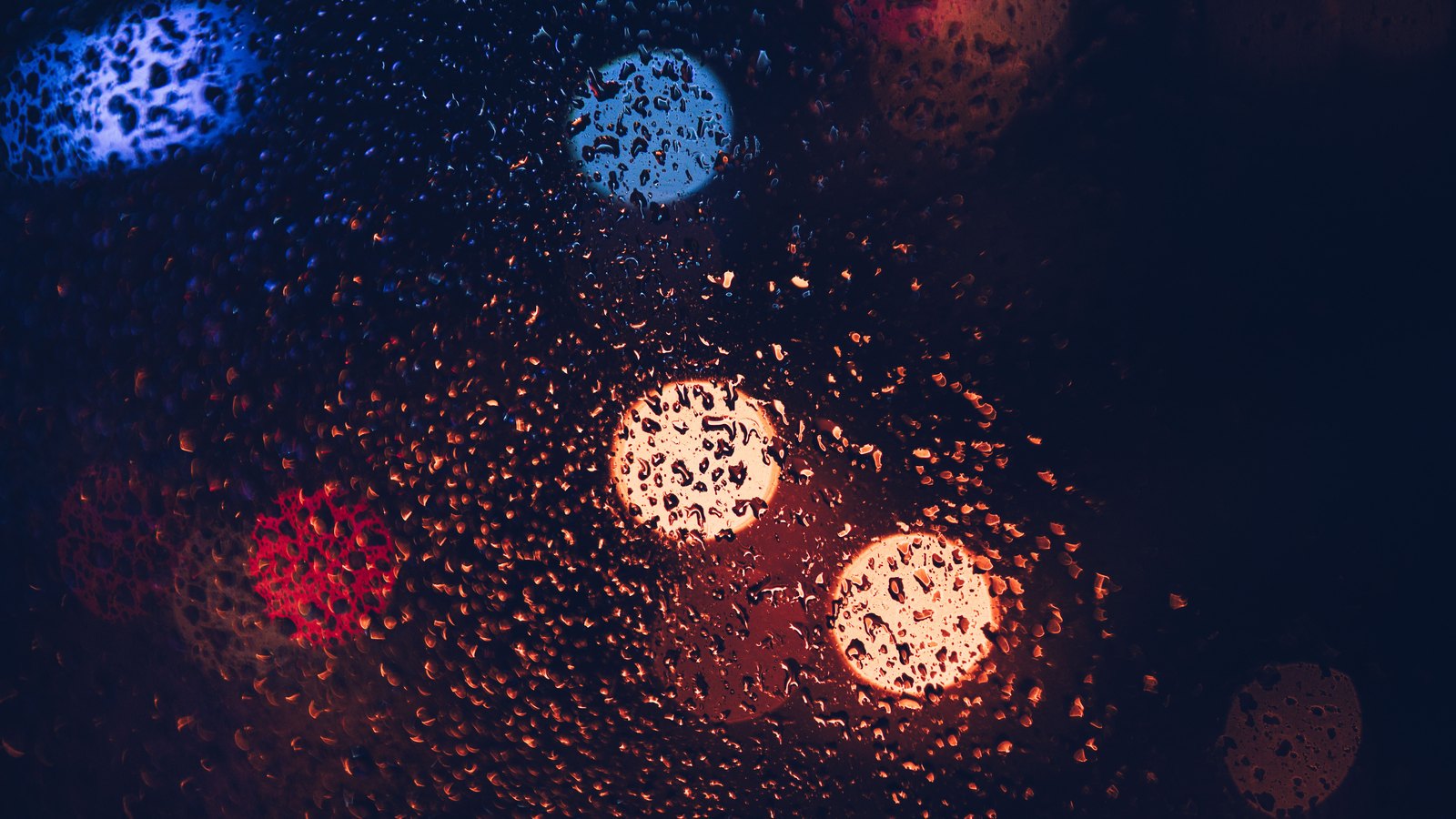 Blurred red and blue lights through rain, not a photograph of the Cape Coral case.