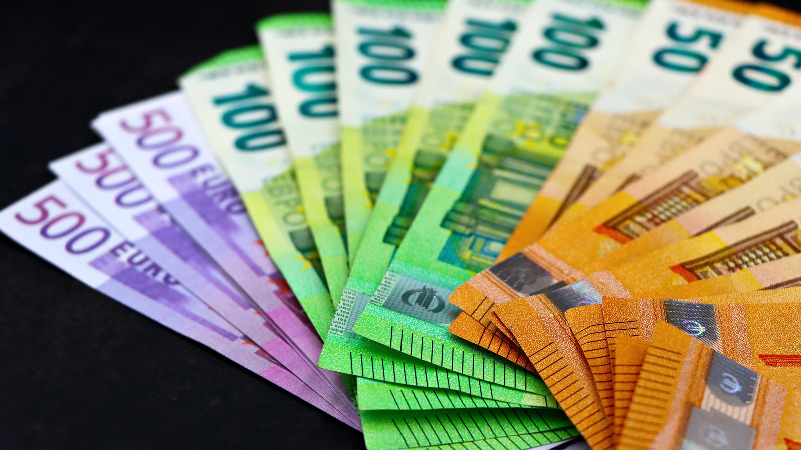 Euro banknotes arranged in a fan on a black background