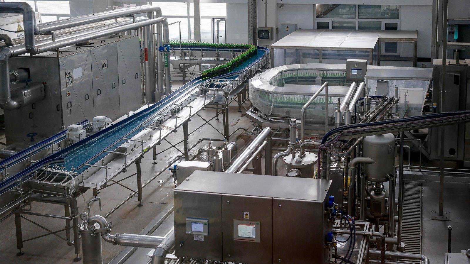Automated beverage bottling equipment and conveyors inside a factory