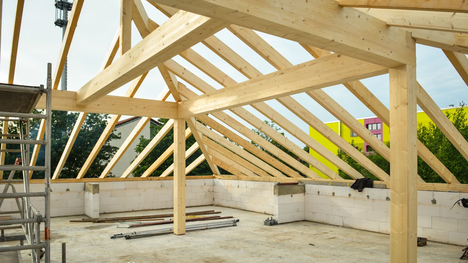New timber roof framing spans a building under construction.