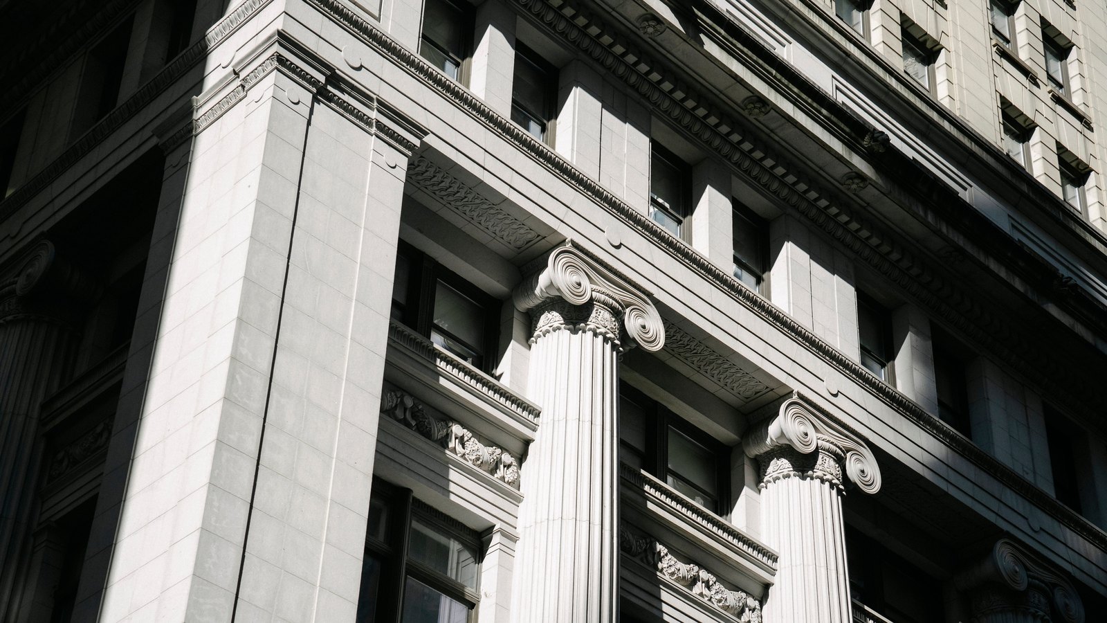 Sunlit stone columns on a neoclassical building, not a photograph of the Reserve Bank of New Zealand.