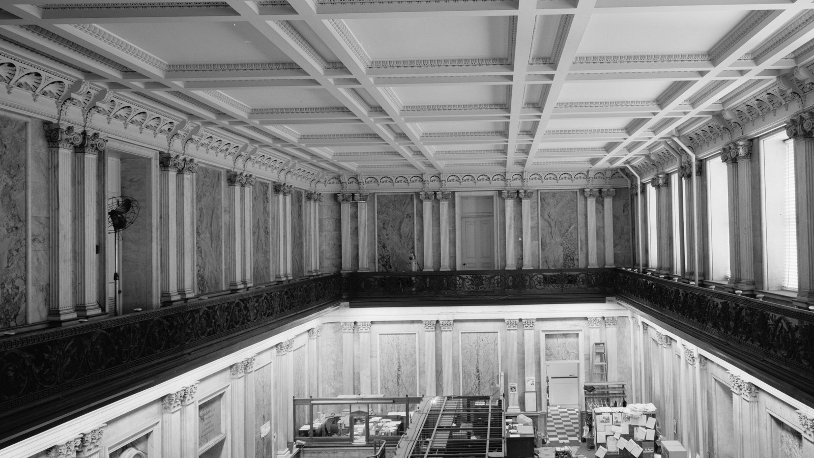 A black-and-white view across the columned Cash Room inside the United States Treasury building.