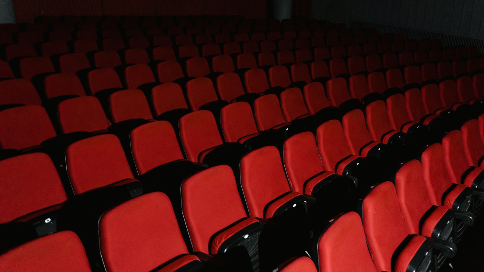 Rows of empty red seats in a generic cinema, not a photograph of the Mercato theater.