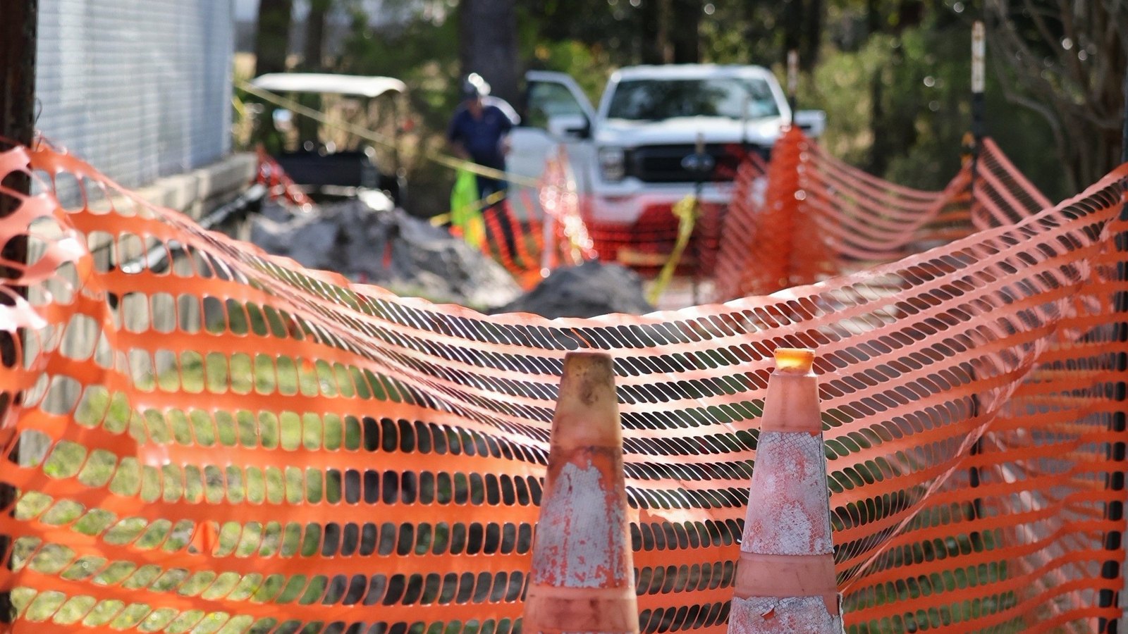 Orange safety barriers and traffic cones surround a generic Florida work area, not a photograph of this event.