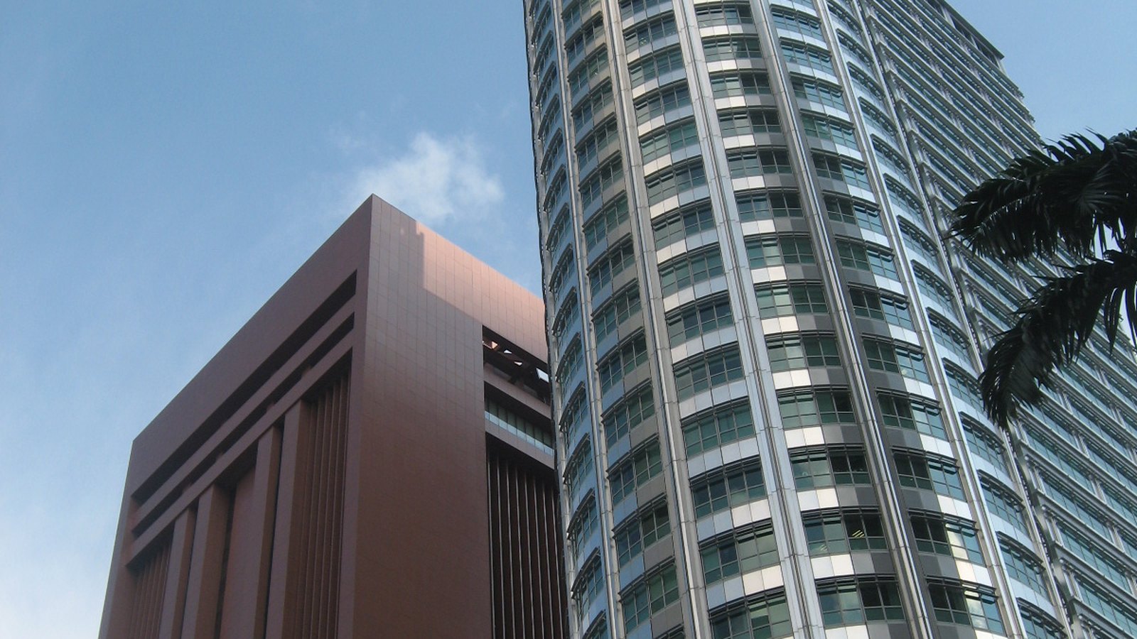 The reddish MAS Building stands beside the glass-fronted Springleaf Tower in Singapore, photographed in June 2006.