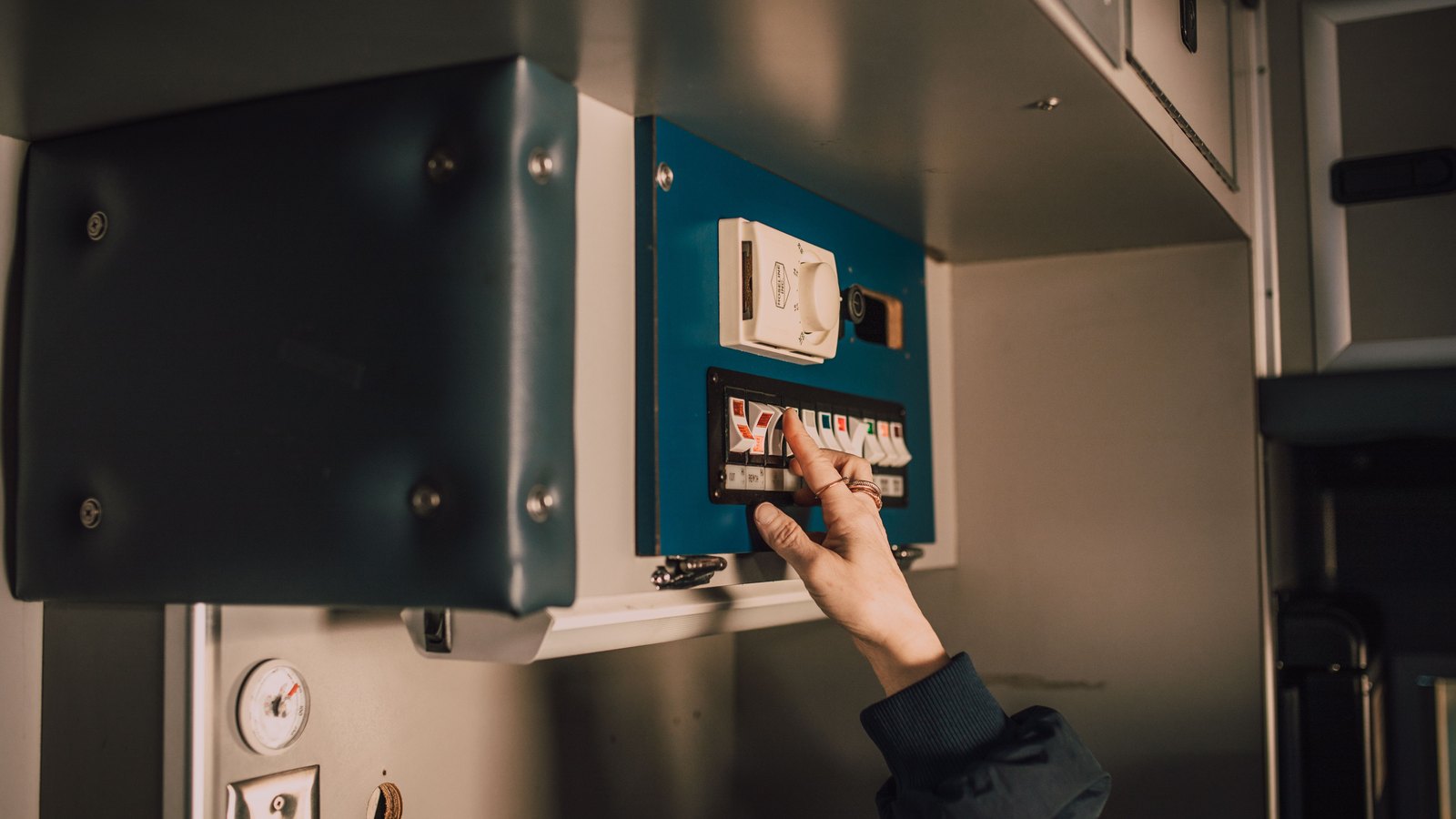 A responder operates switches inside an ambulance, not a photograph of this event.