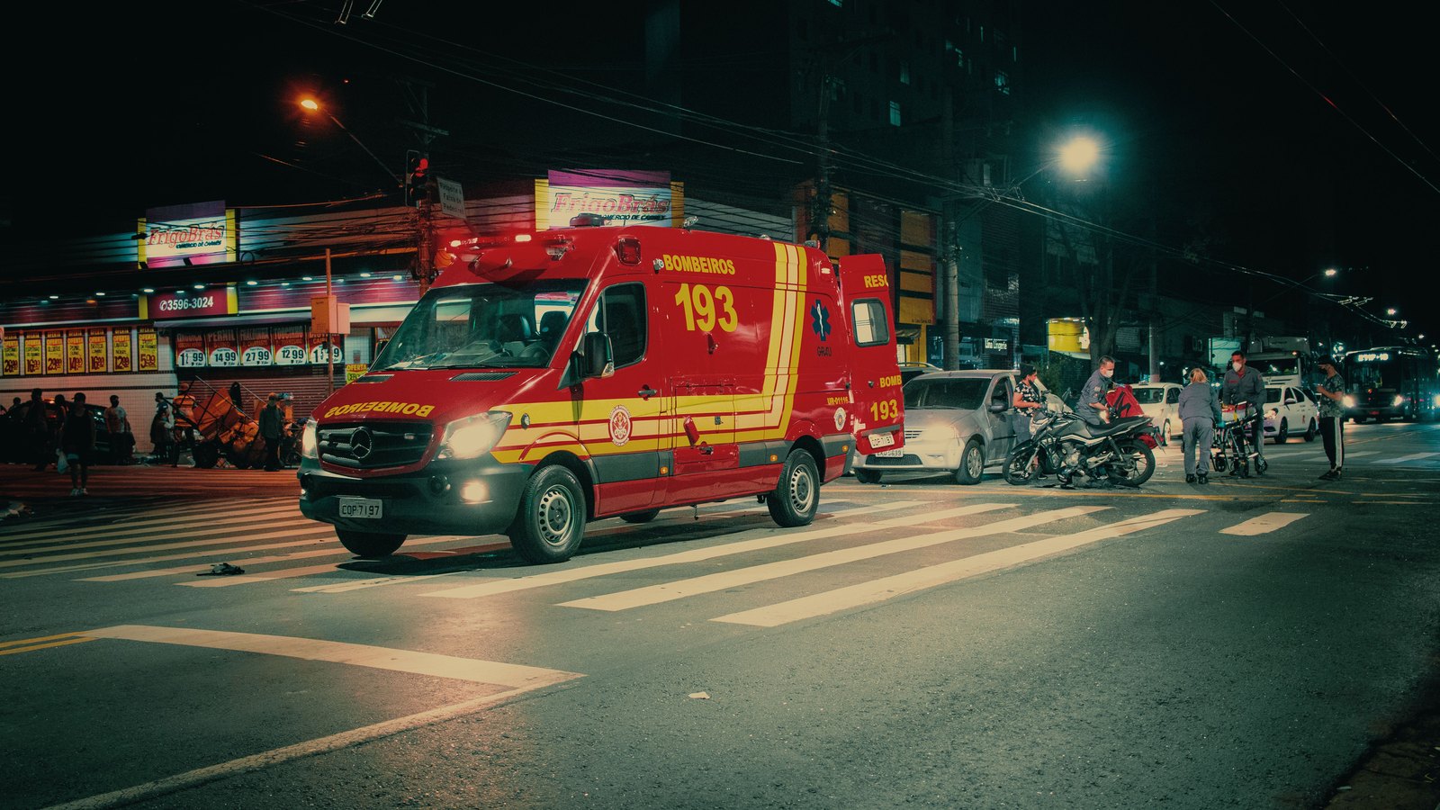 An emergency response vehicle with red lights on a street at night.