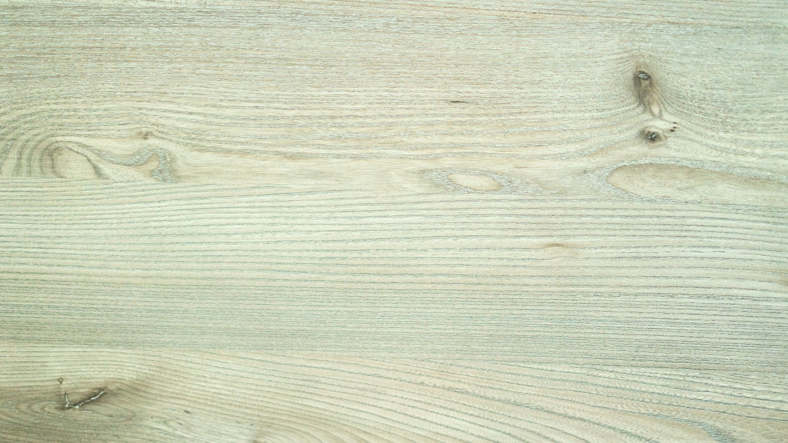 A close crop of a pale sanded wood board, its grain running horizontally in fine lines through several small dark knots, used as an illustration. It is not a photograph of this crash or of the Six Mile Cypress corridor.