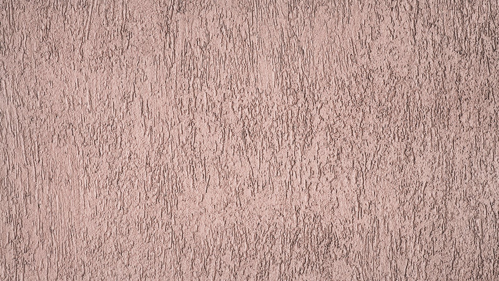 A close crop of a rendered plaster wall in a dusty pinkish brown, its surface combed into fine vertical ridges and pits, used as an illustration. It is not a photograph of this crash or of the Six Mile Cypress corridor.