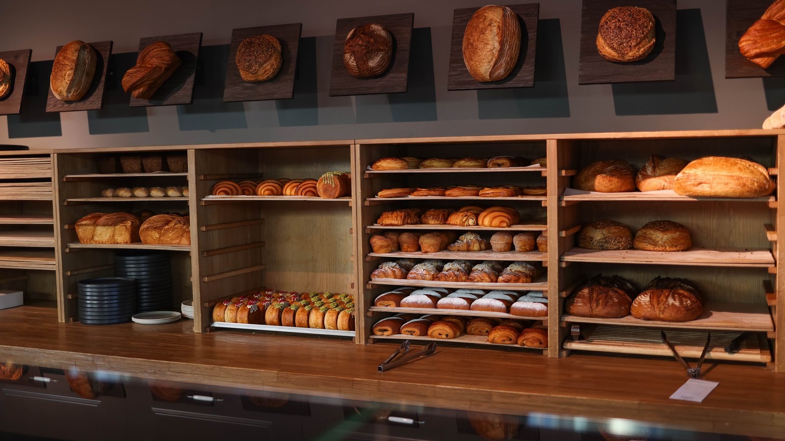 Loaves and pastries arranged on shelves behind a bakery counter.