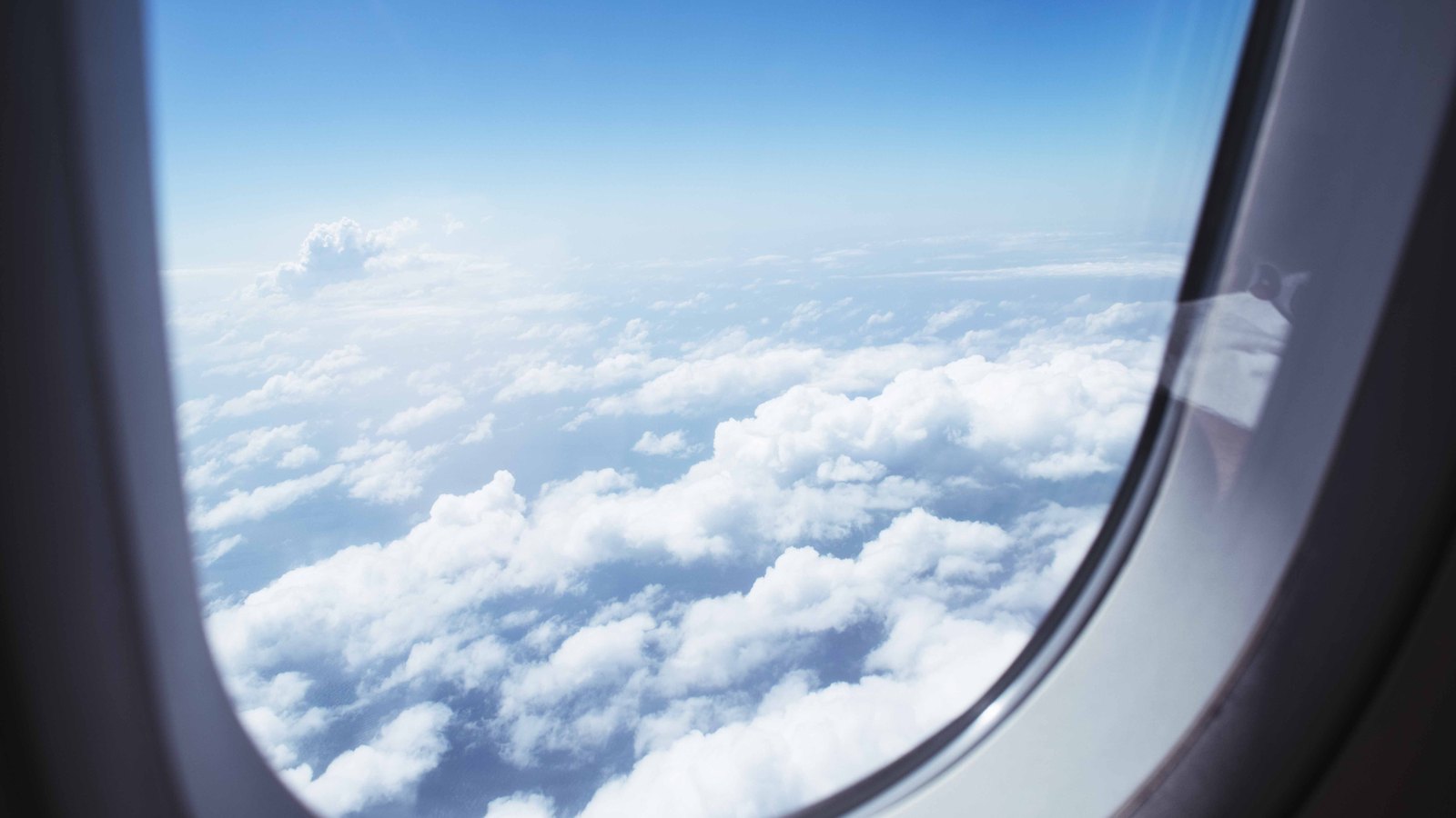 A photograph illustrating view from airplane window clouds.