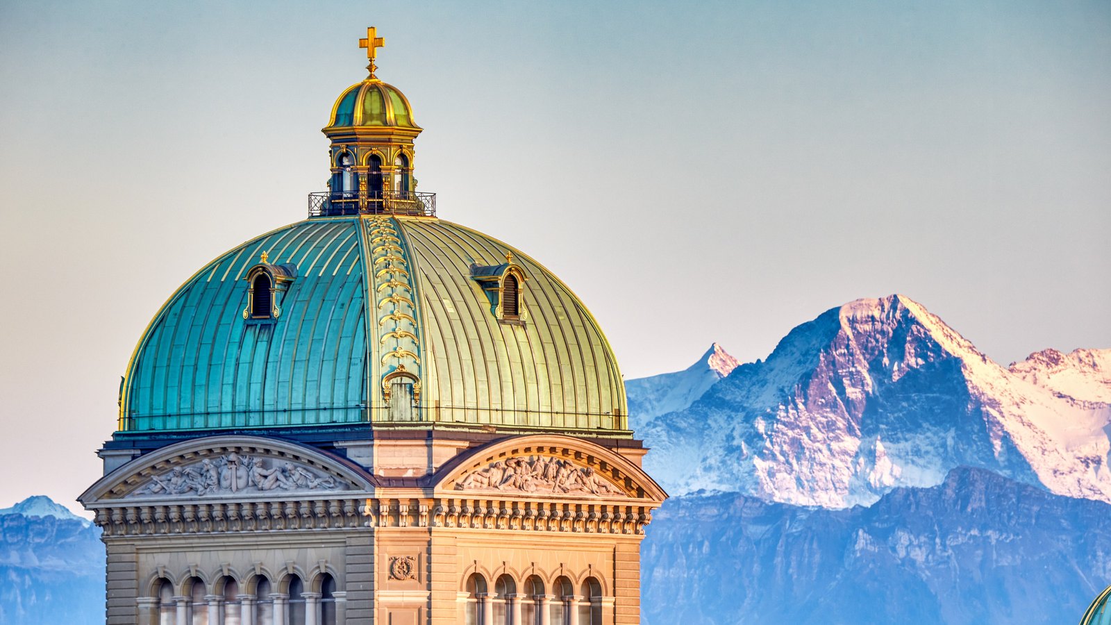 The copper dome of Switzerland's Federal Palace in Bern with the Eiger behind it.