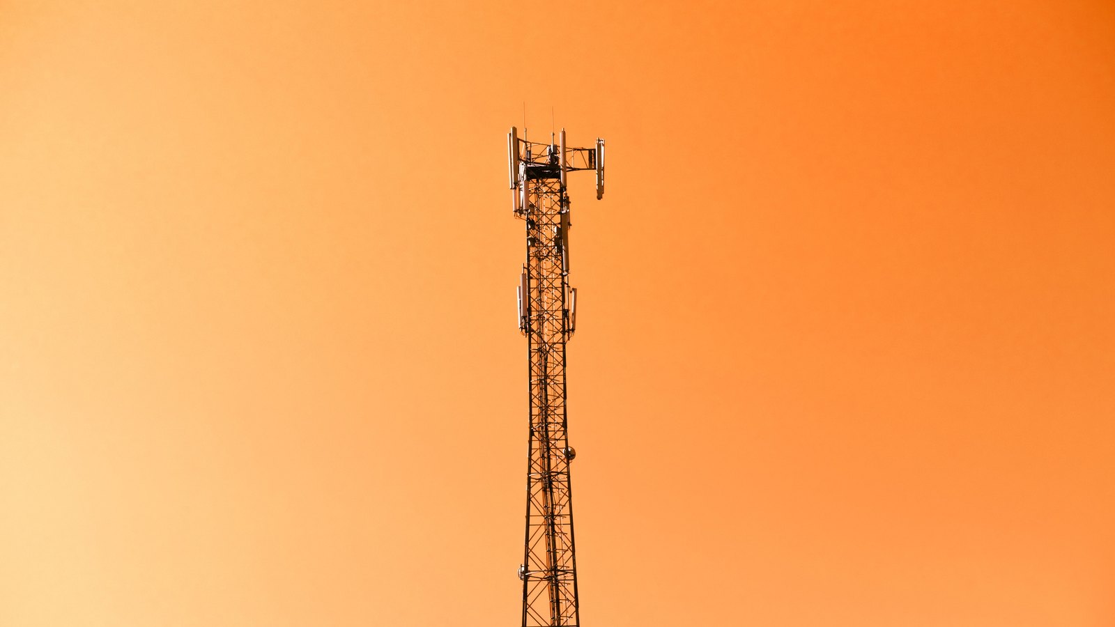 A photograph illustrating cell tower against clear sky.