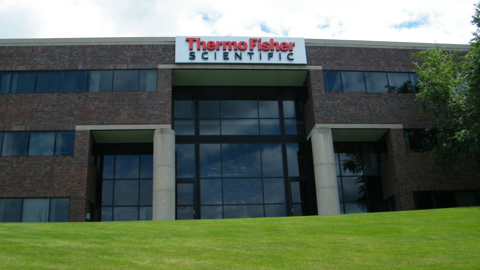 Red Thermo Fisher Scientific lettering above the glass entrance of a brick company building in Waltham, Massachusetts, photographed in 2009.