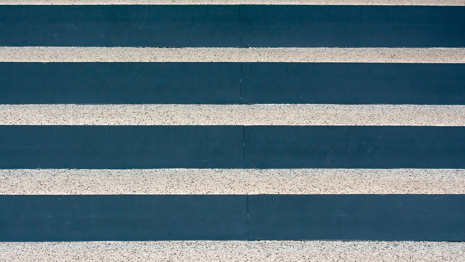 Broad horizontal bands fill the whole frame: flat dark teal painted risers alternating with pale speckled aggregate treads, photographed square on. A faint vertical seam runs down the middle of the painted bands. No horizon, sky, doorway, person, vehicle or lettering is in the picture.
