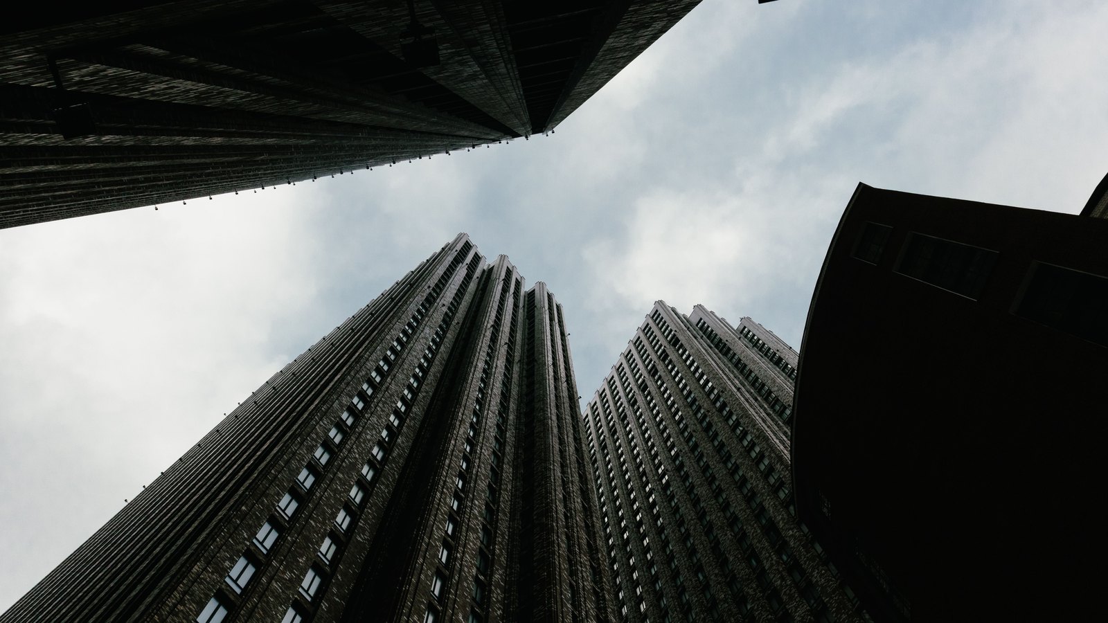 A photograph illustrating skyscraper looking up sky.
