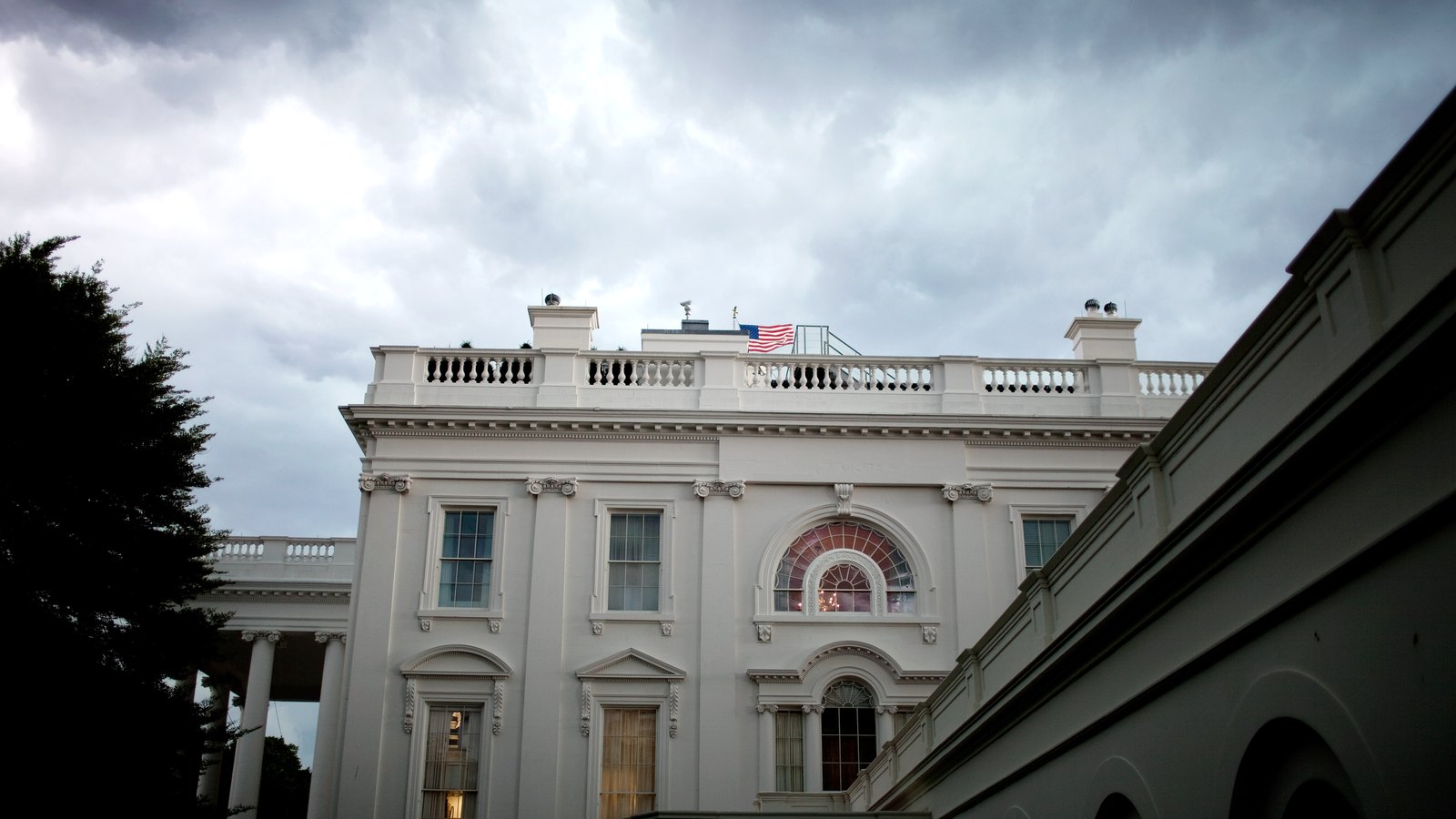 The west side of the White House beneath heavy clouds.