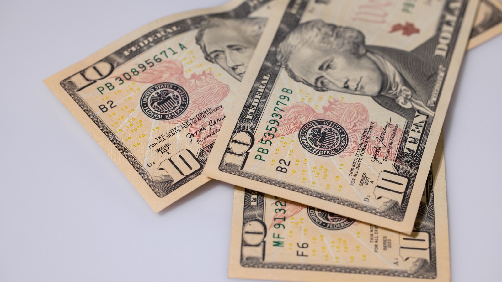 Several United States ten dollar bills arranged on a plain surface, illustrating funds available for a stock repurchase.