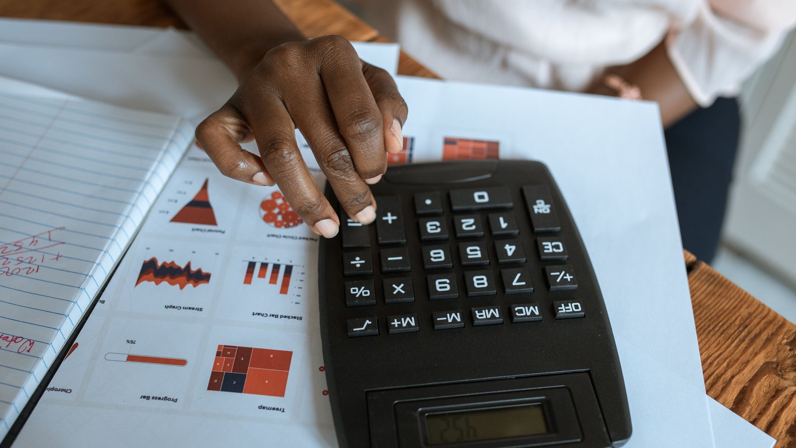 A photograph illustrating calculator on printed financial figures.