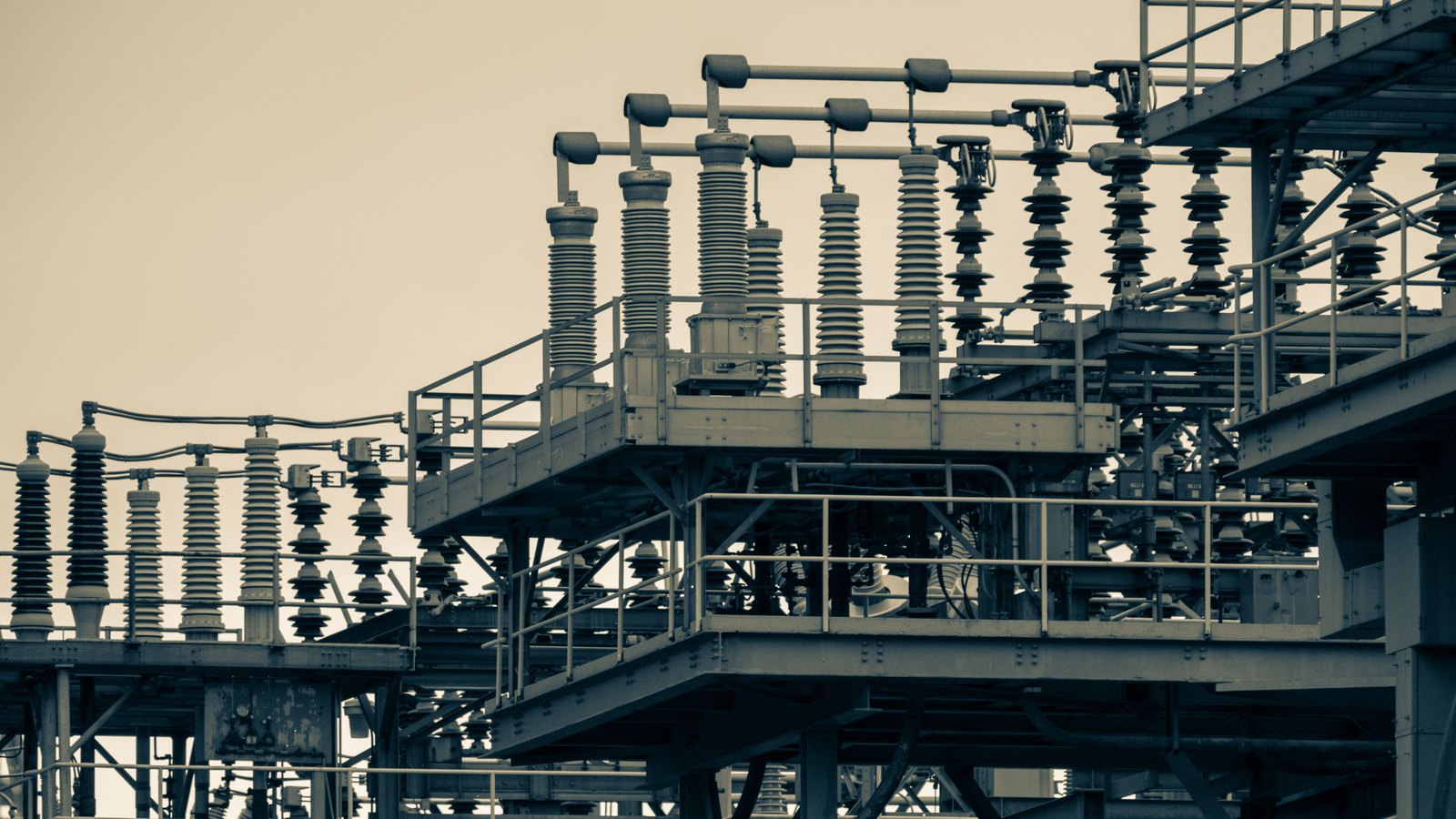 High-voltage electrical switchgear and insulators at an industrial power substation.