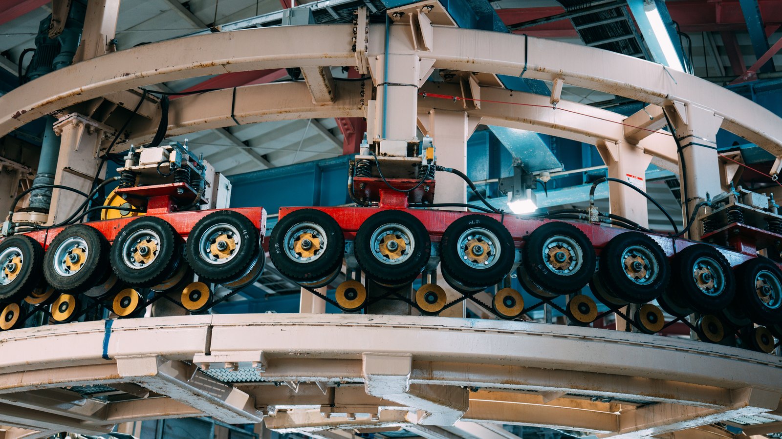 Tires move through an industrial conveyor system on a manufacturing line.