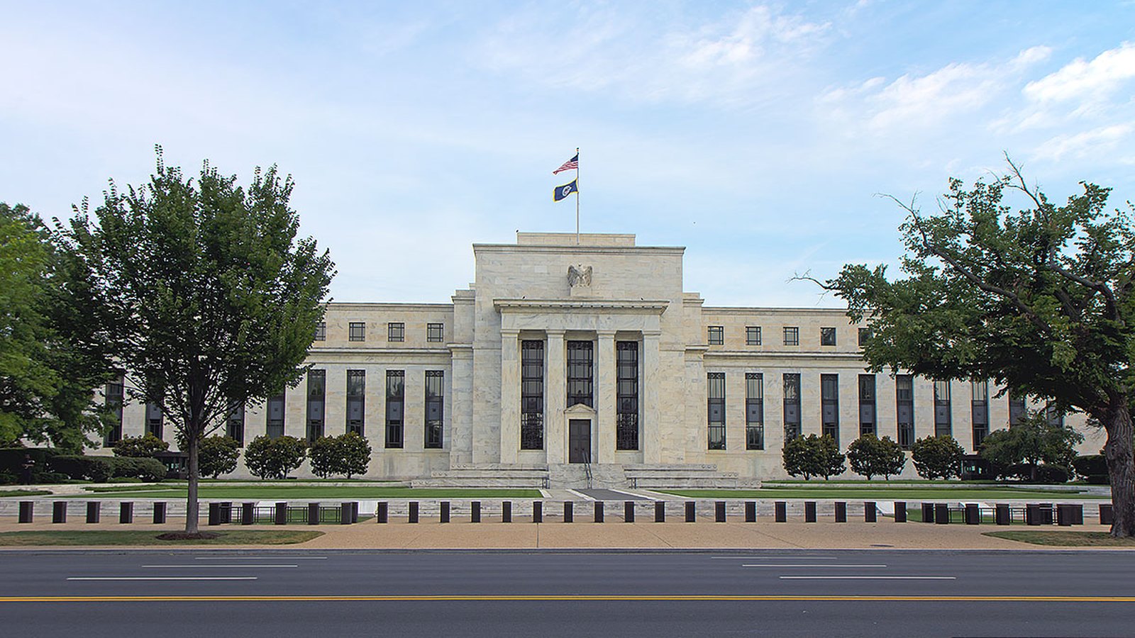 The Federal Reserve building in Washington, with its columned entrance and flags.