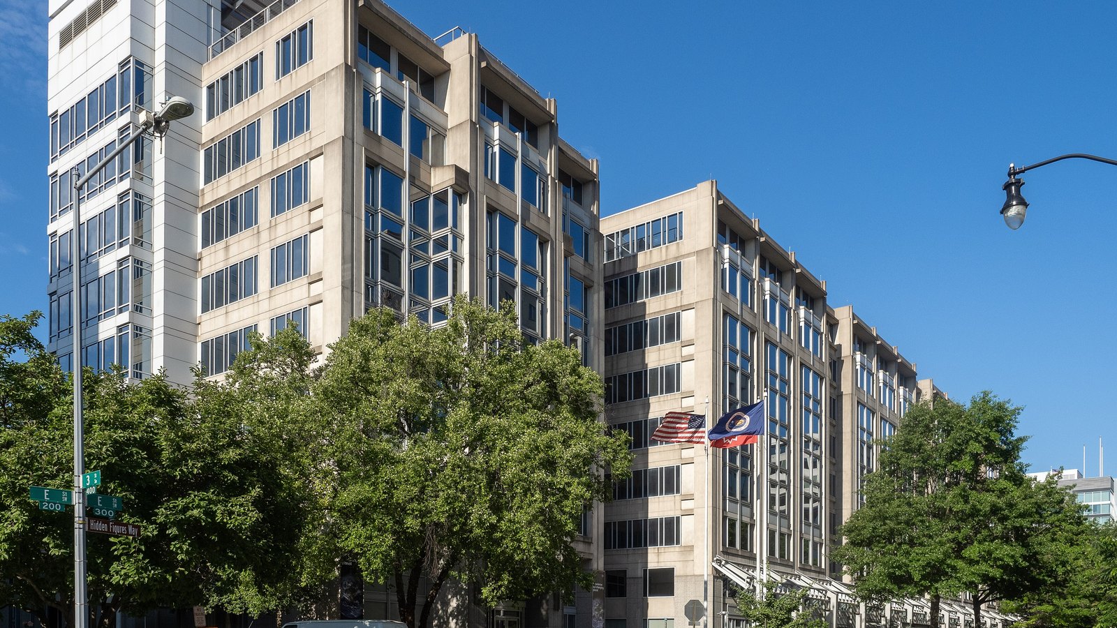 The Mary W. Jackson NASA Headquarters building in Washington, with the NASA entrance sign and flags visible.