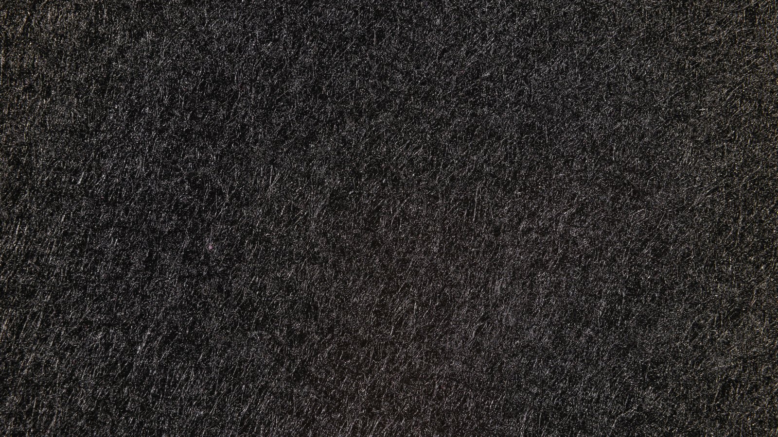 A full frame close crop of a dark, coarse, evenly grained surface, filling the whole picture. No people, vehicles, road markings, signage, horizon or legible text are visible, and no place can be identified from it. Pexels titles it a close up of a black rough surface. An abstract texture used as a plain illustration, not a photograph of US-41, of Estero or of this crash.