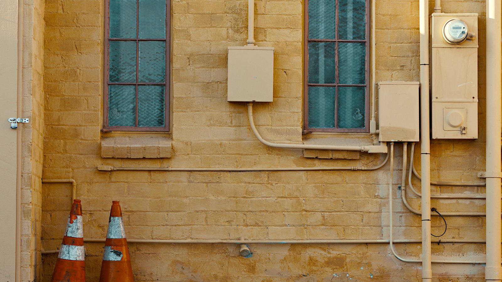 Orange traffic cones stand beside a brick wall, not a photograph of this event.