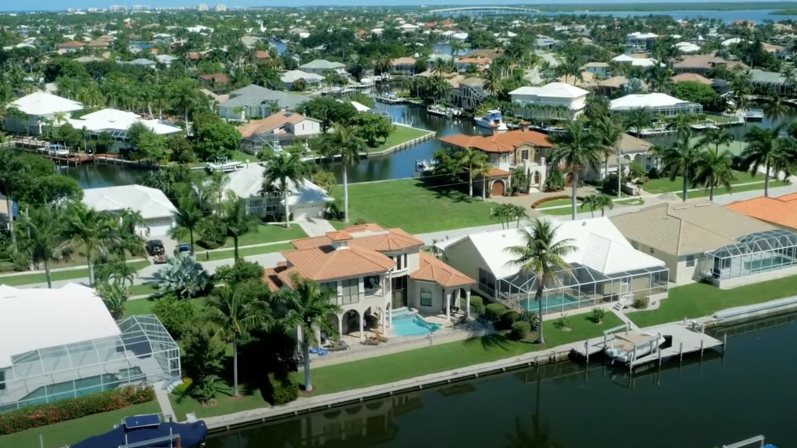 An aerial view of canal-front homes and screened pools on Marco Island.