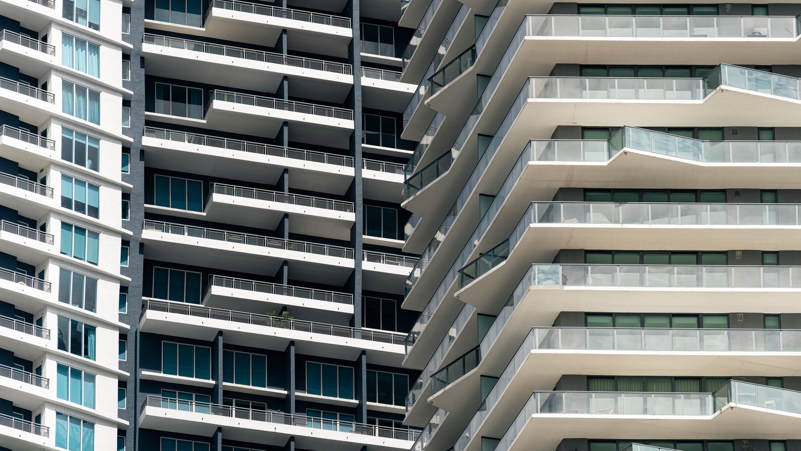 Two contemporary residential towers photographed in a tight architectural crop, their stacked balconies filling the frame.