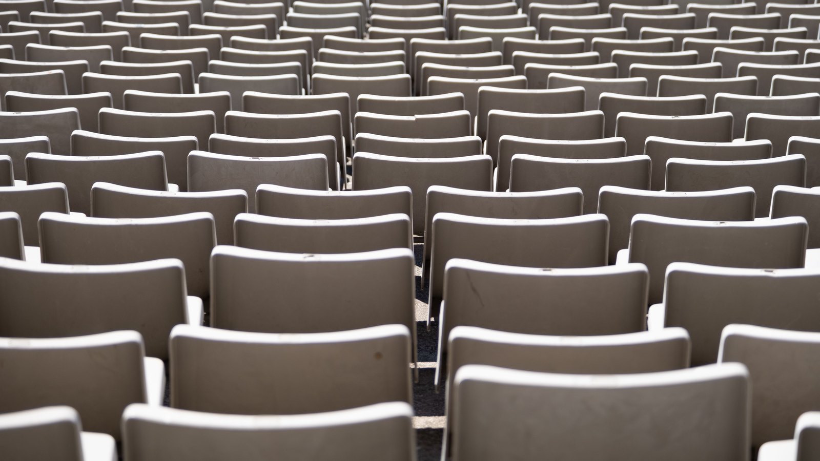 Rows of identical grey plastic chairs, receding row on row to the edge of the frame.