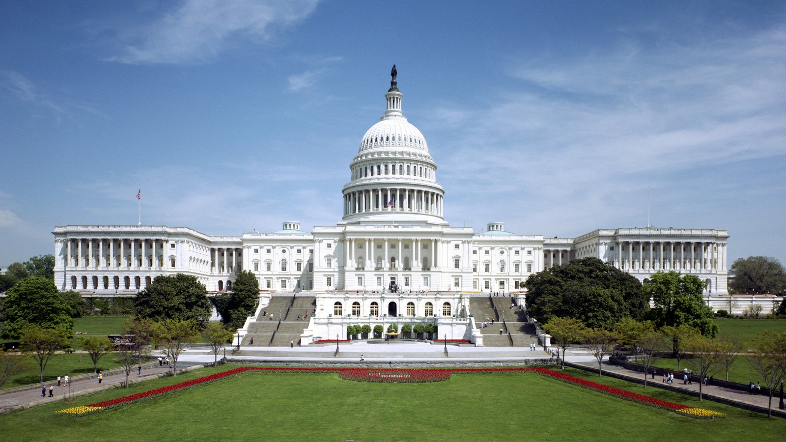 The west front of the United States Capitol in Washington, its dome centred above the terraced steps and lawn.
